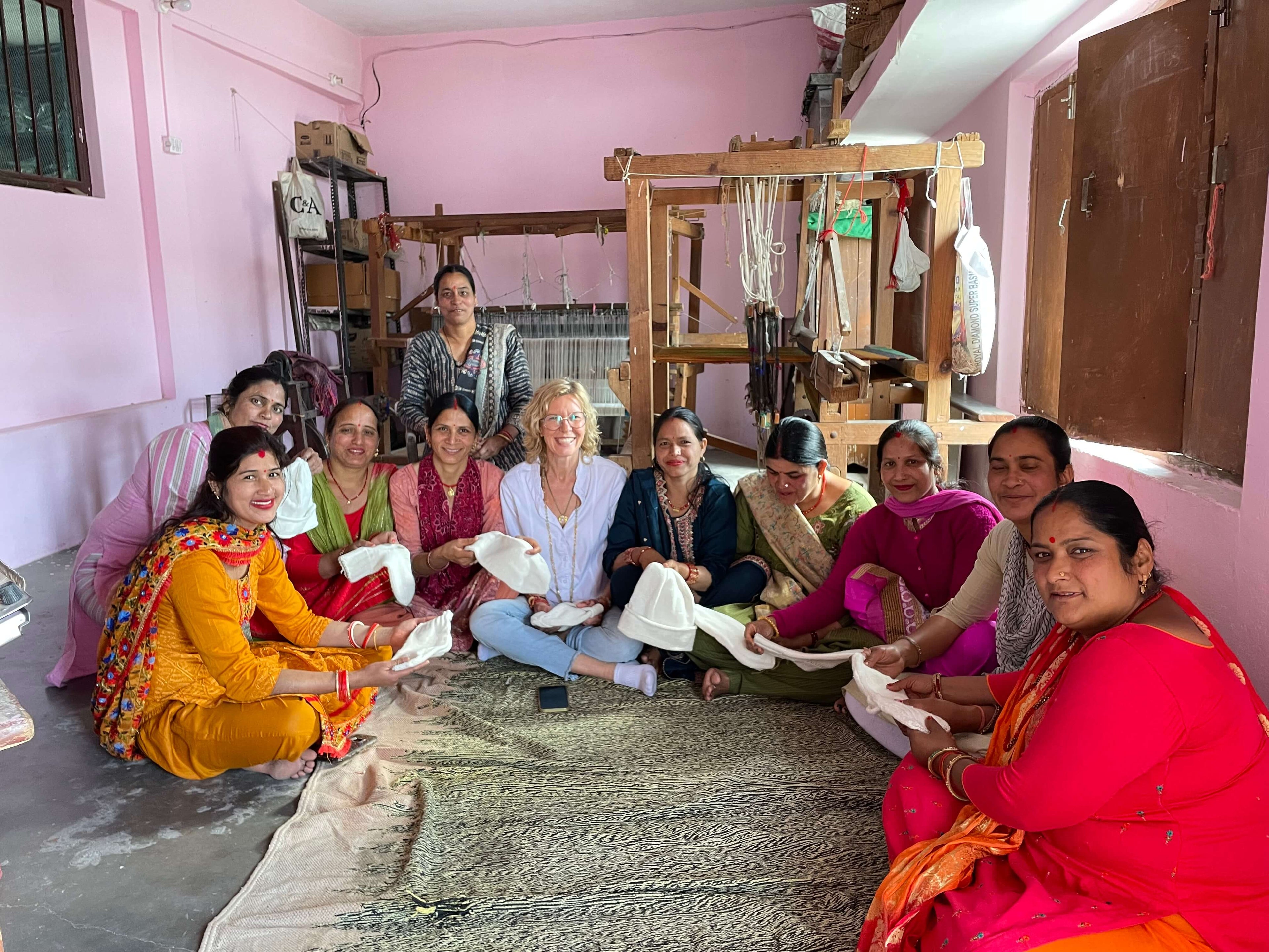 Karina Santjohanser mit Weberinnen an Webstühlen in Chamba, Uttarakhand — handgefertigte Angora-Schals, faire Löhne, Patenschaften für Kinder in Nepal
